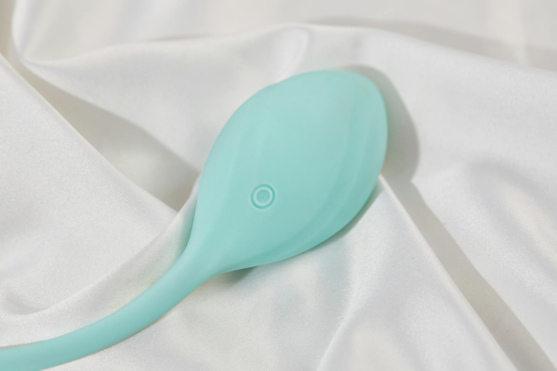 Ein eleganter Vibrator auf cremefarbener Seide, das glatte Design und die hochwertige Verarbeitung hervorhebend