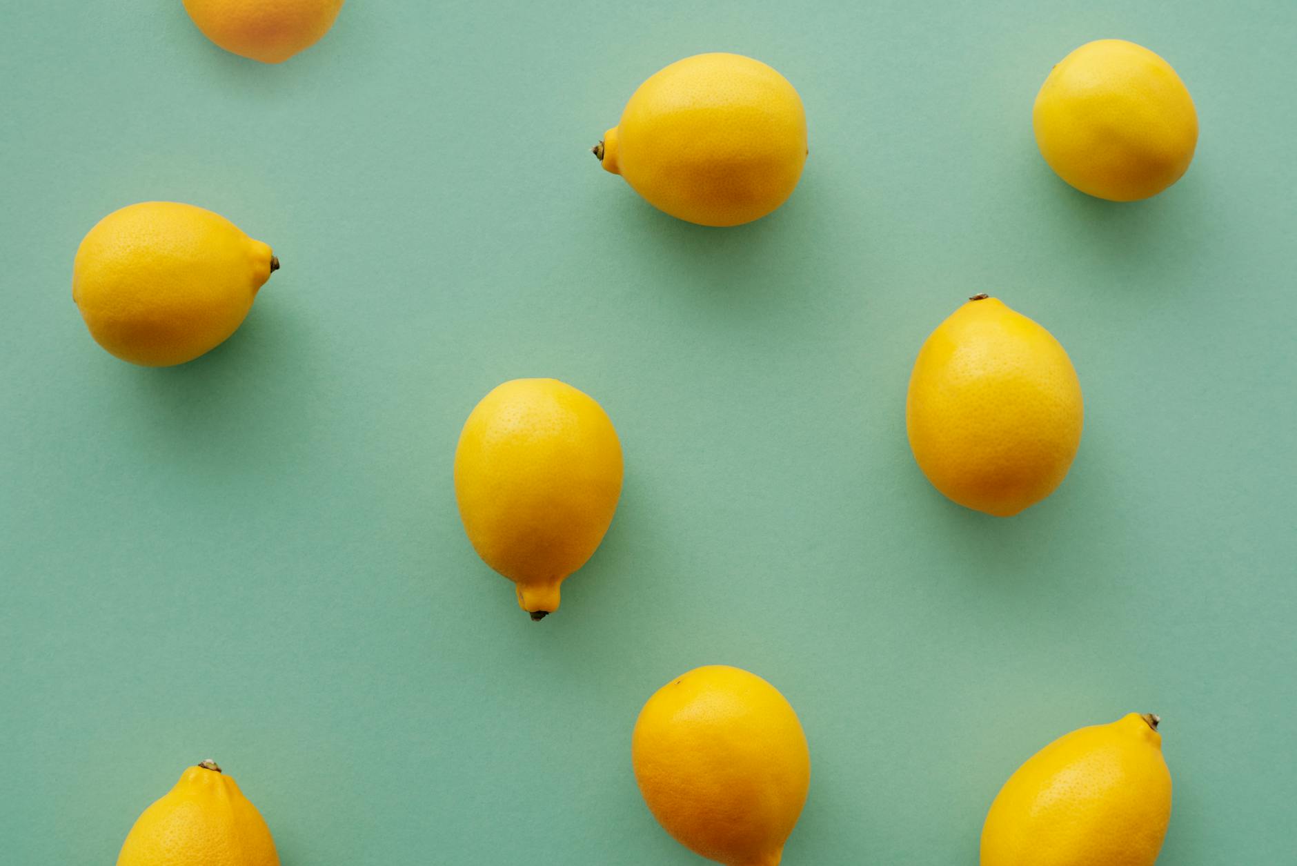Fresh lemons on a pastel green background, symbolizing fresh approaches to pleasure