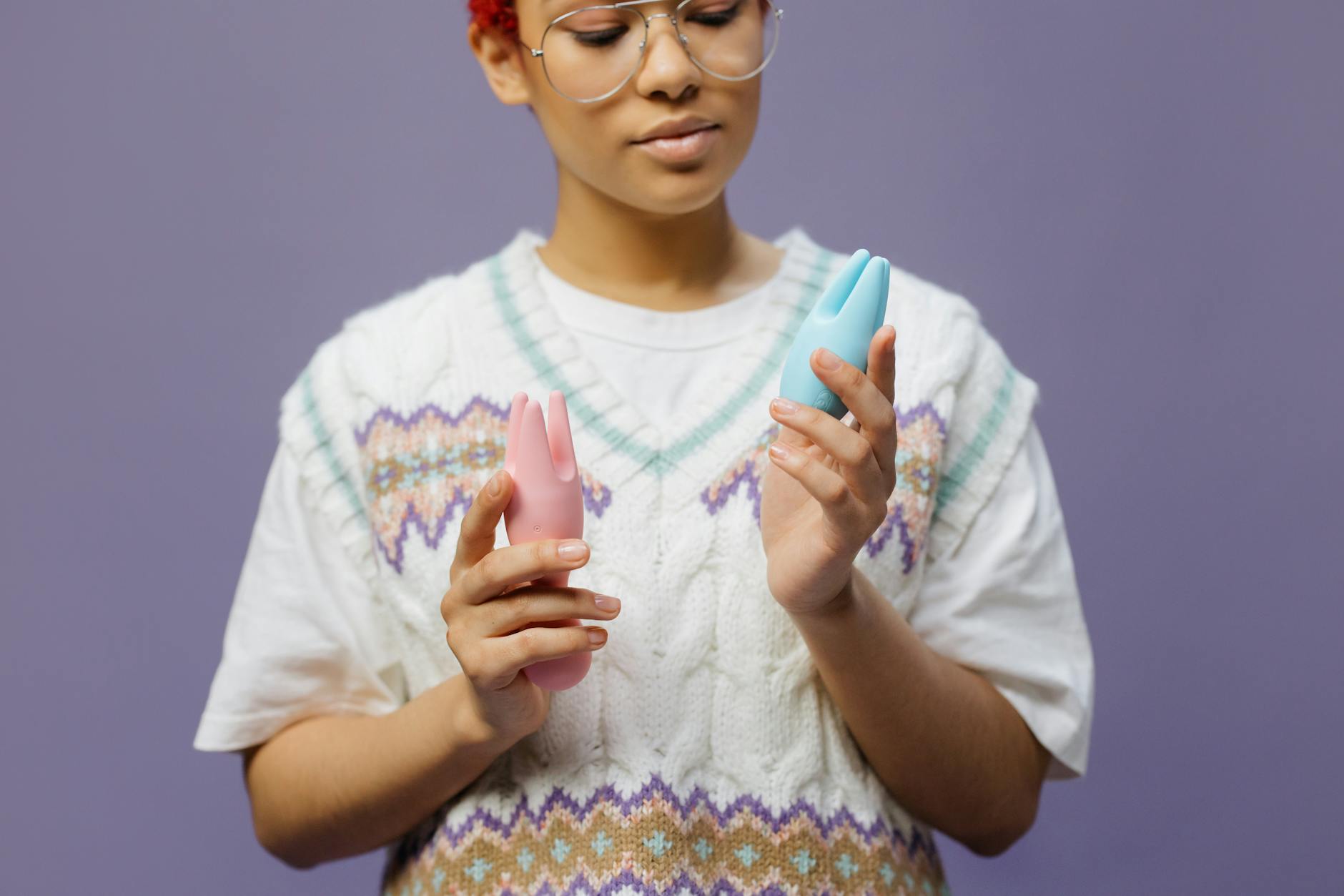 Woman holding silicone vibrators in a contemplative pose, representing pleasure without pressure or pain.