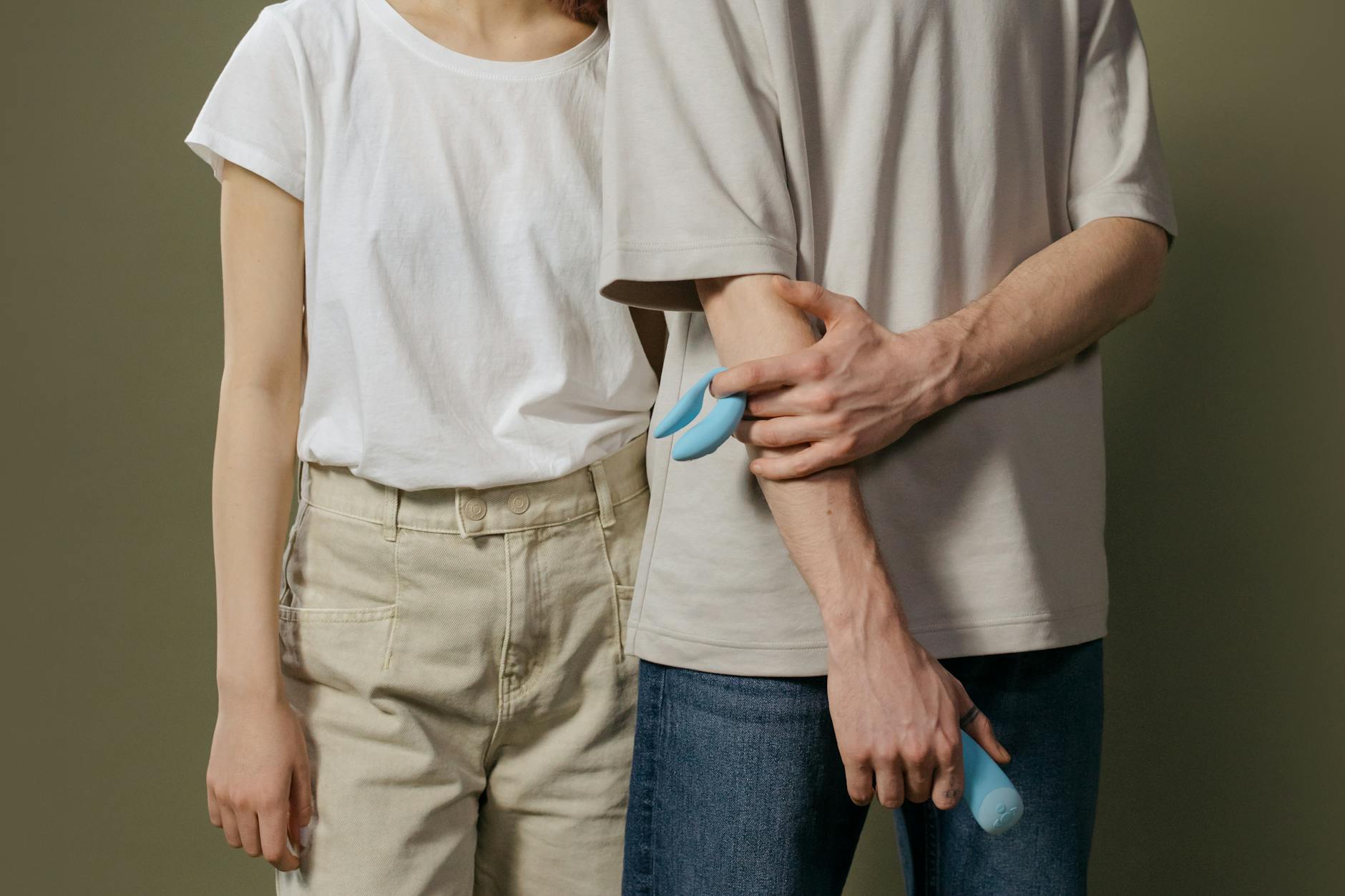Frau hält blaue und rosa Silikonvibriatoren in nachdenklicher Pose