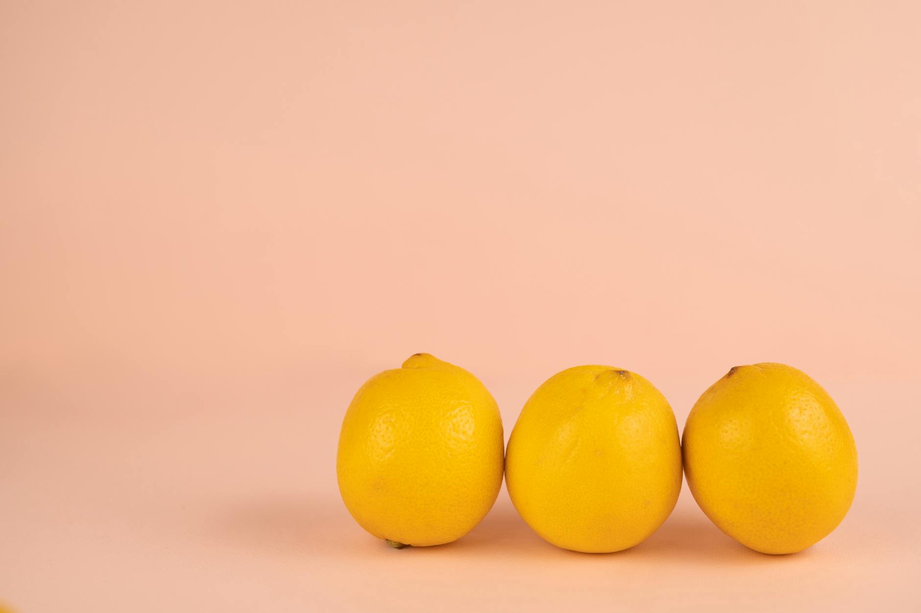Bright yellow lemons arranged on pastel background