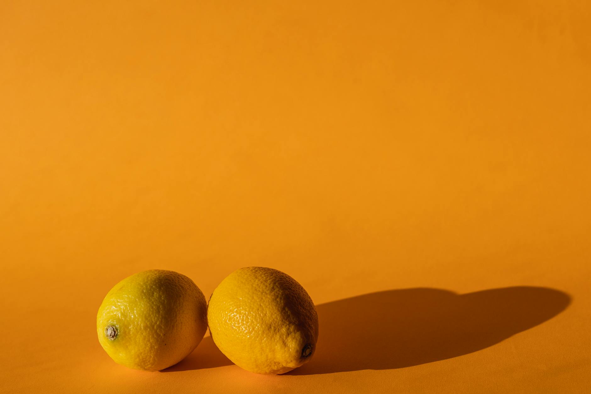 Fresh ripe lemons on a pastel background, symbolizing natural pleasure and timing